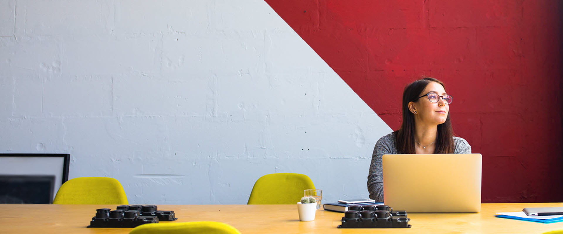 women sitting at table working on laptop looking out window