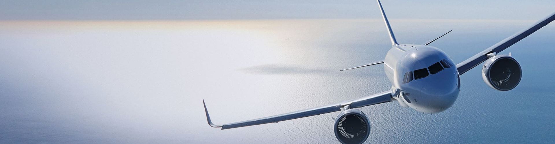 Un avion de ligne blanc vole au-dessus de l'océan