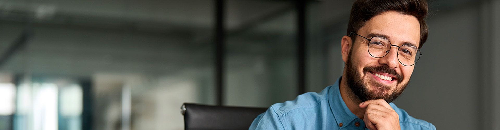 Alt : Homme dans une entreprise souriant devant un ordinateur