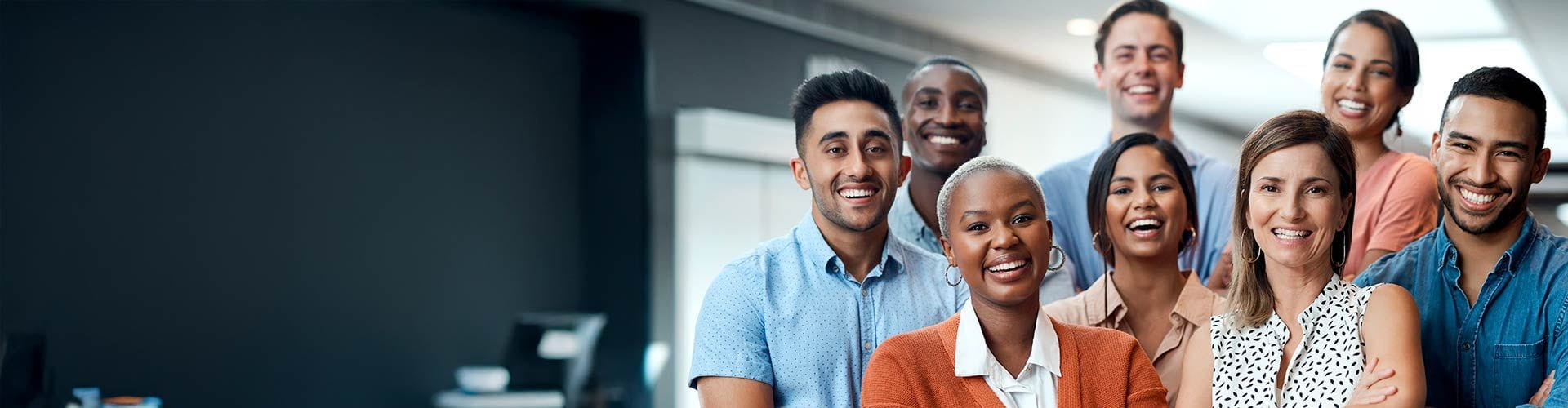Groupe de 8 personnes dans une entreprise croisant les bras et souriant devant l’objectif Groupe de 8 personnes dans une entreprise croisant les bras et souriant devant l’objectif