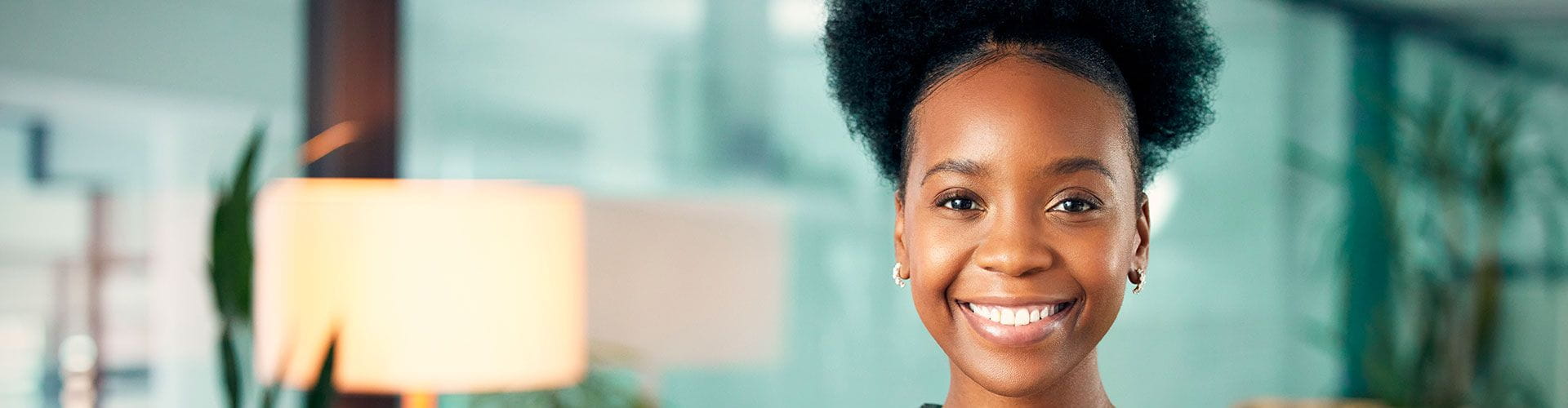 Femme souriante face à l’objectif dans un milieu professionnel Femme souriante face à l’objectif dans un milieu professionnel