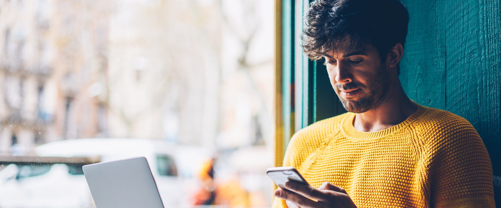 man in yellow sweater looking at tablet man in yellow sweater looking at tablet