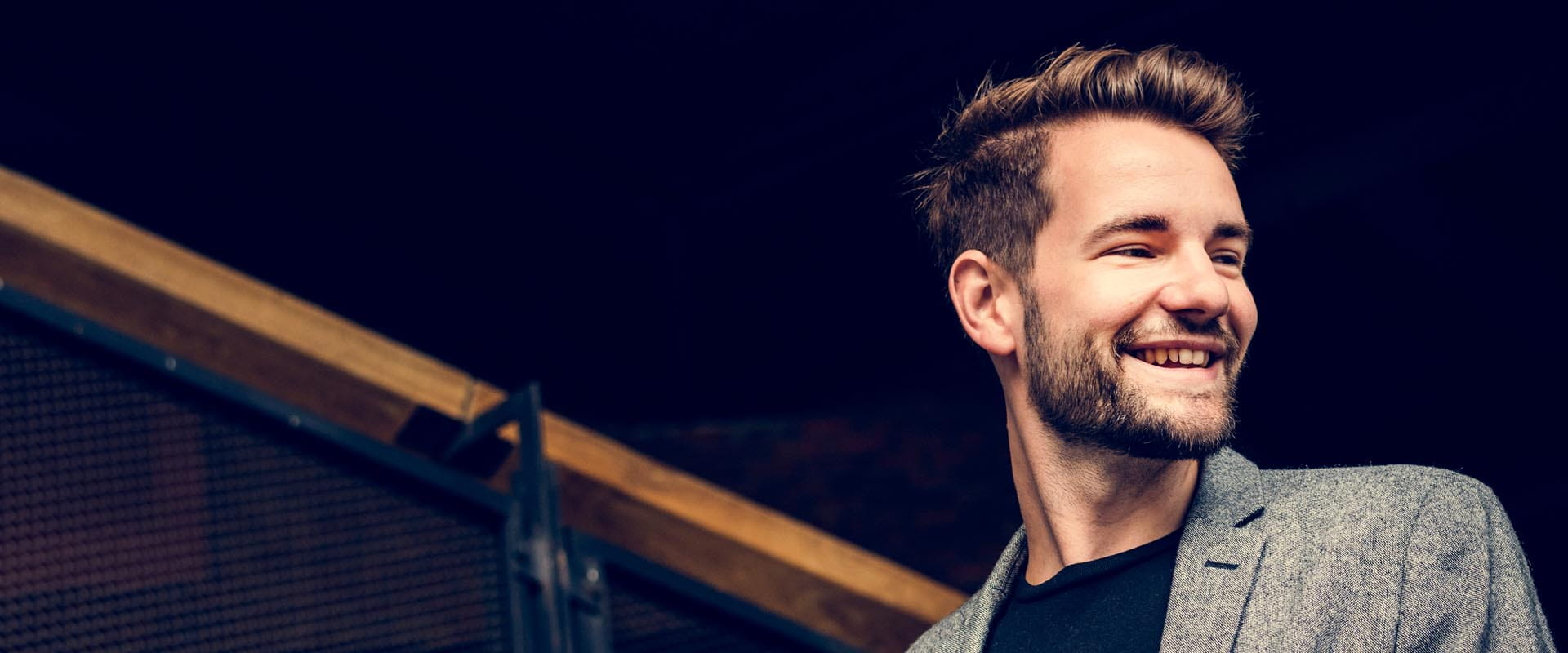 Male coworker smiling confidently in an office environment Male coworker smiling confidently in an office environment