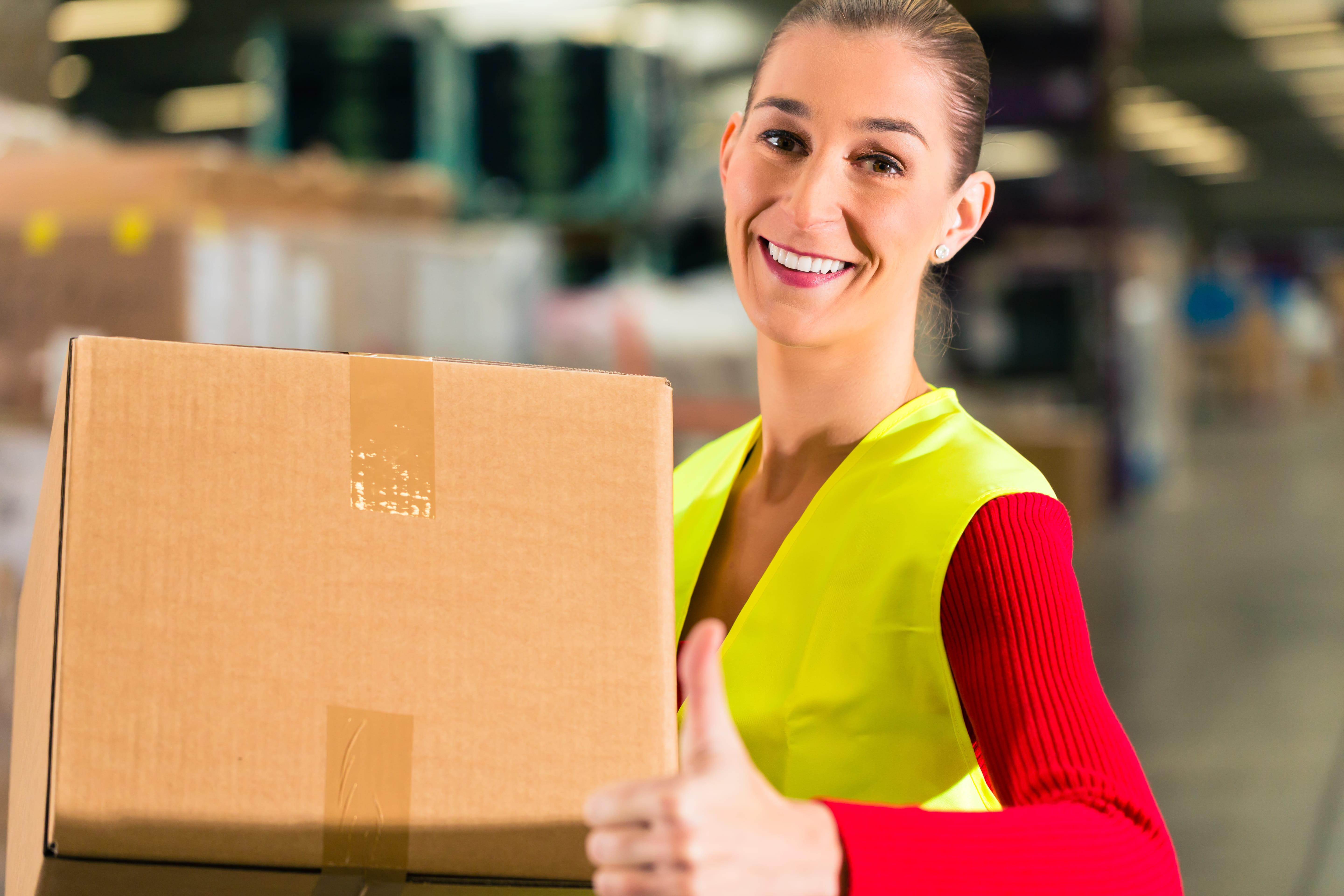 woman in warehouse holding box
