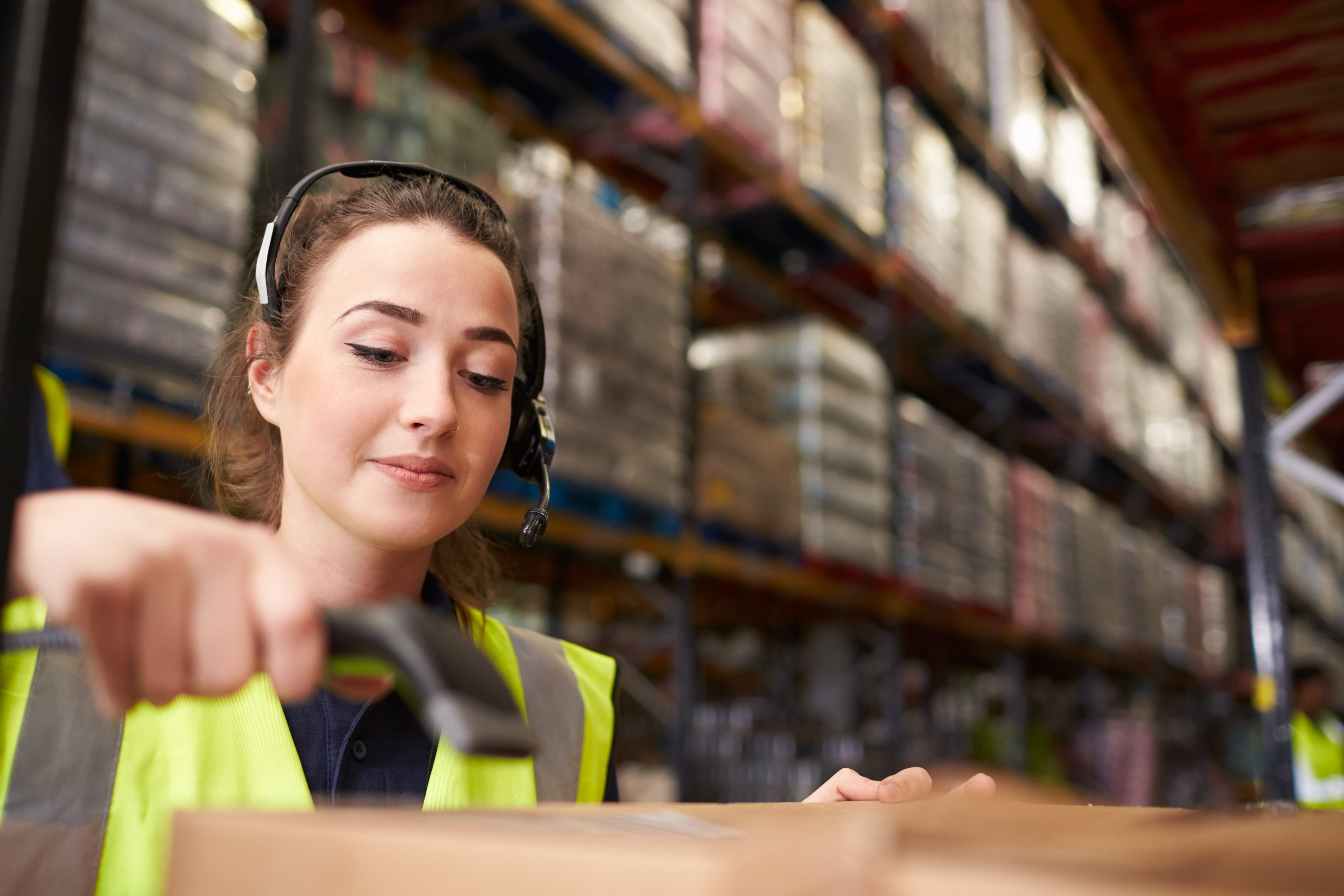 worker in warehouse labeling boxes