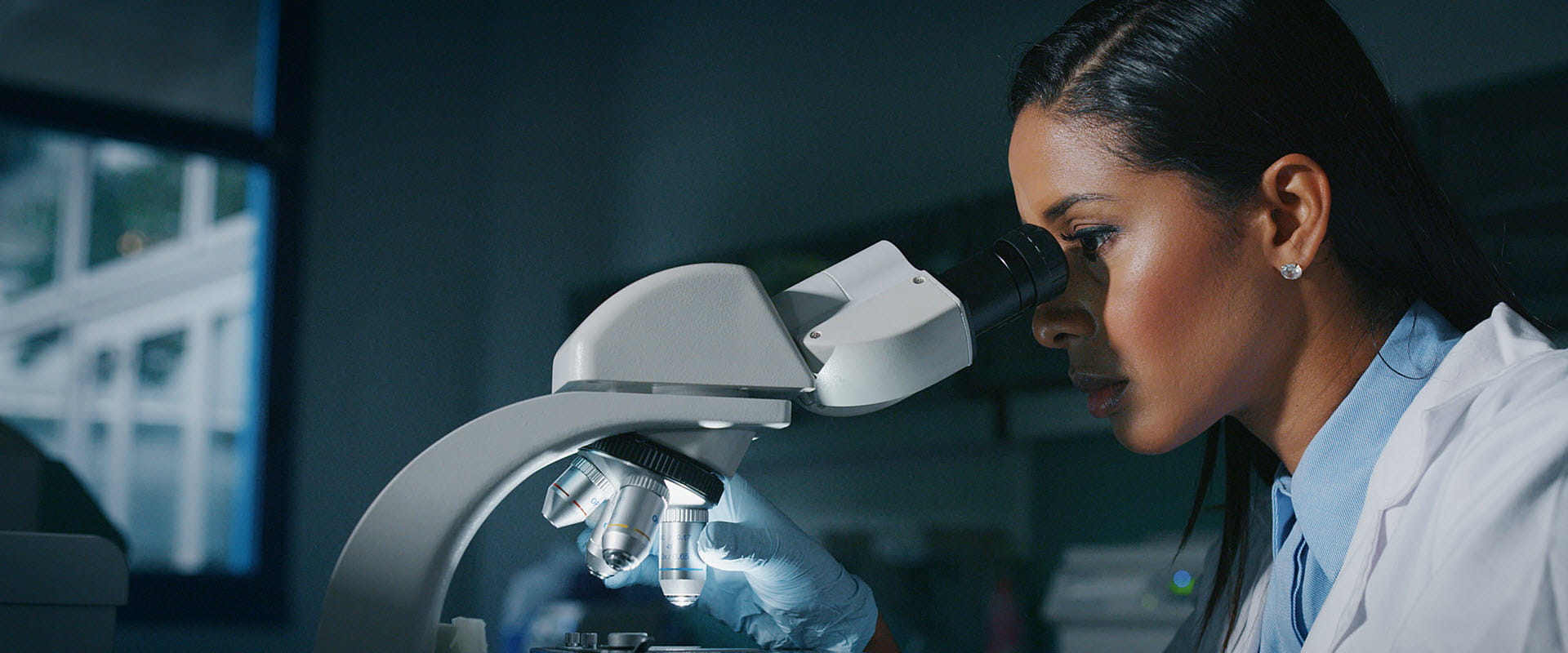 woman looking through microscope woman looking through microscope