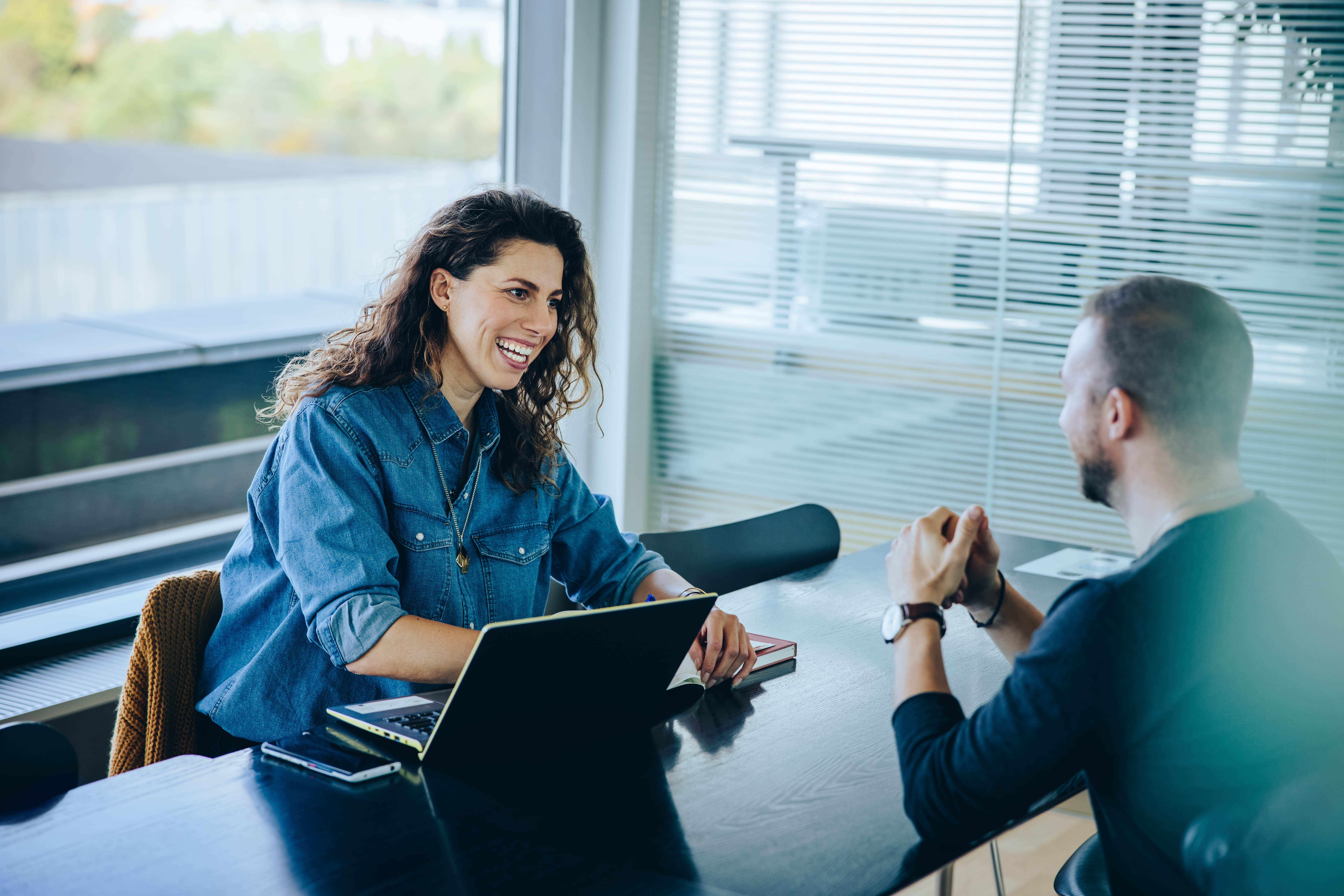 two people having conversation at desk