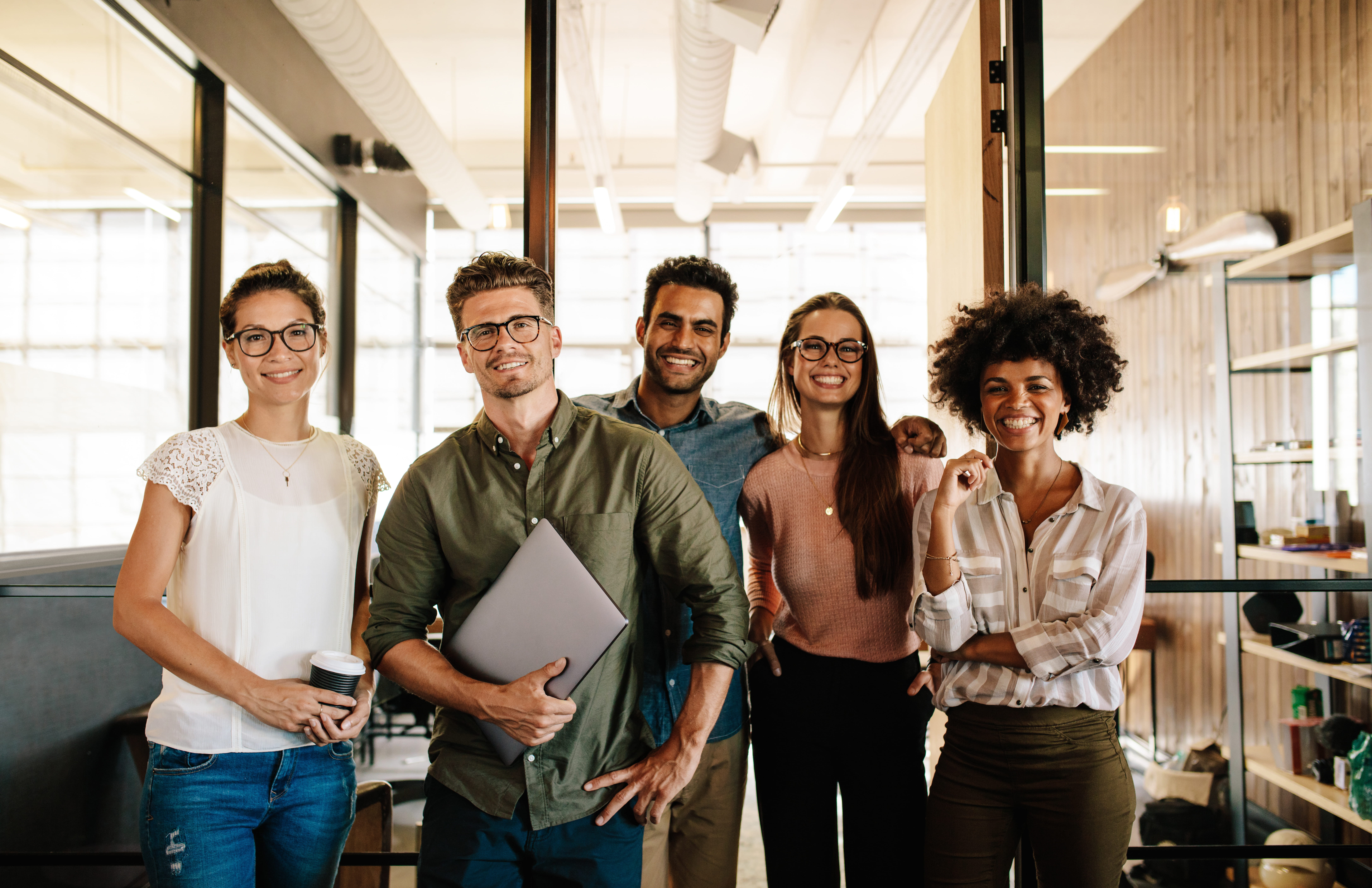 group of five professionals in office looking at camera group of five professionals in office looking at camera