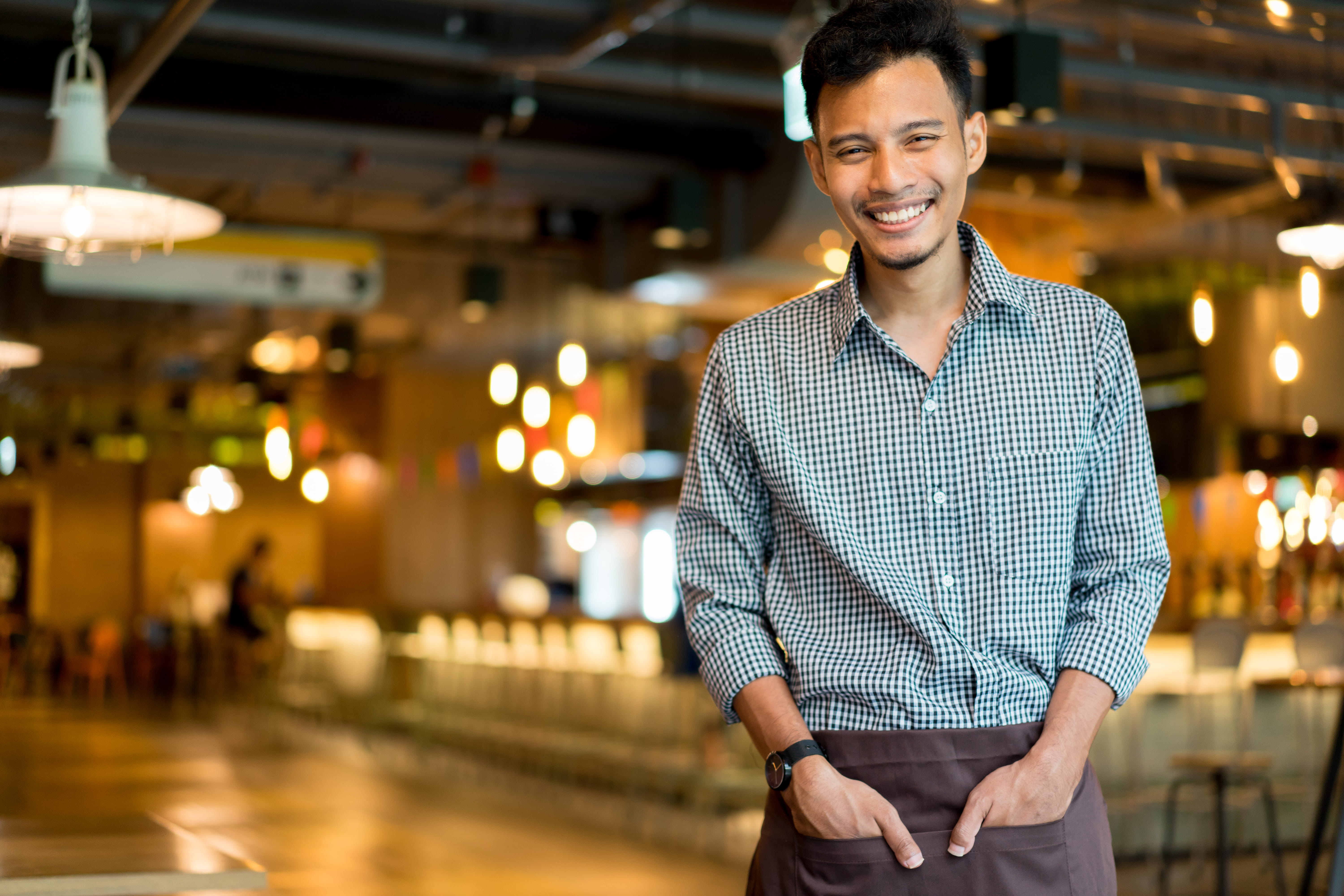 young waiter smiling in restaurant 